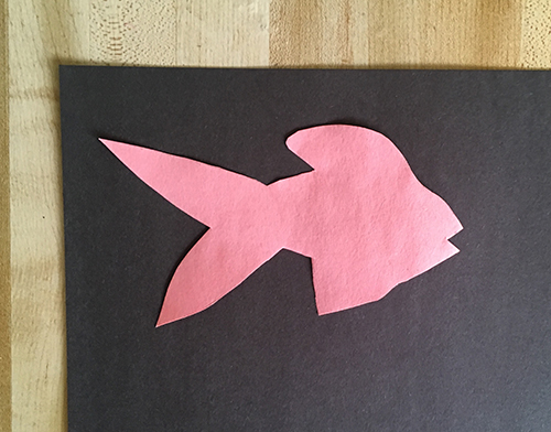 Pink fish shape placed on black construction paper