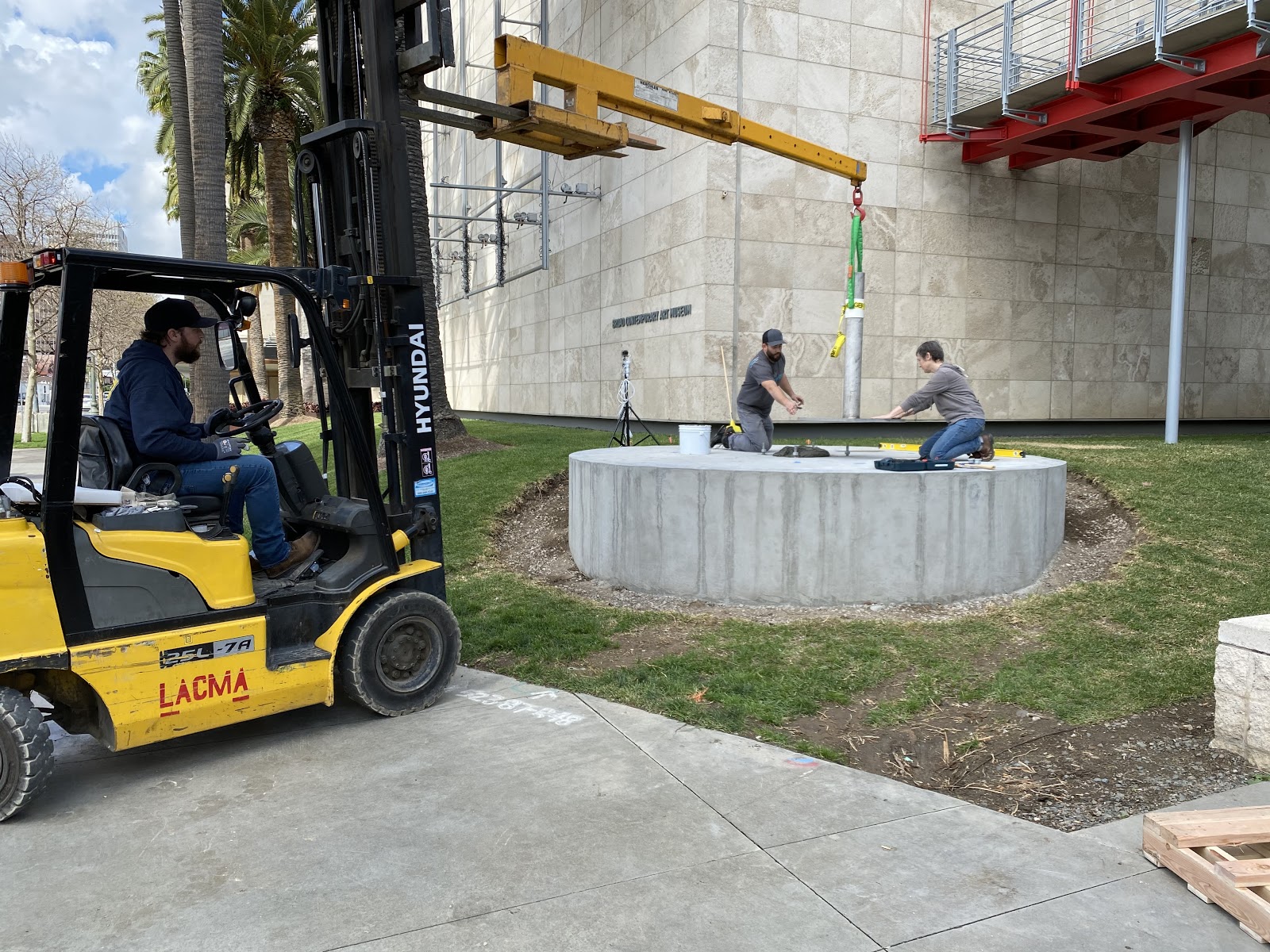 The day before the sculpture arrived, we installed its mount onto the concrete pedestal. We worked closely with Manager of Gallery Construction Jeff Young, to embed anchor bolts in the exact locations needed in the concrete pad as it was poured. From left to right Jordan Mesavage, Luke Boehnke, and Julia Latané. Photo by Elspeth Patient