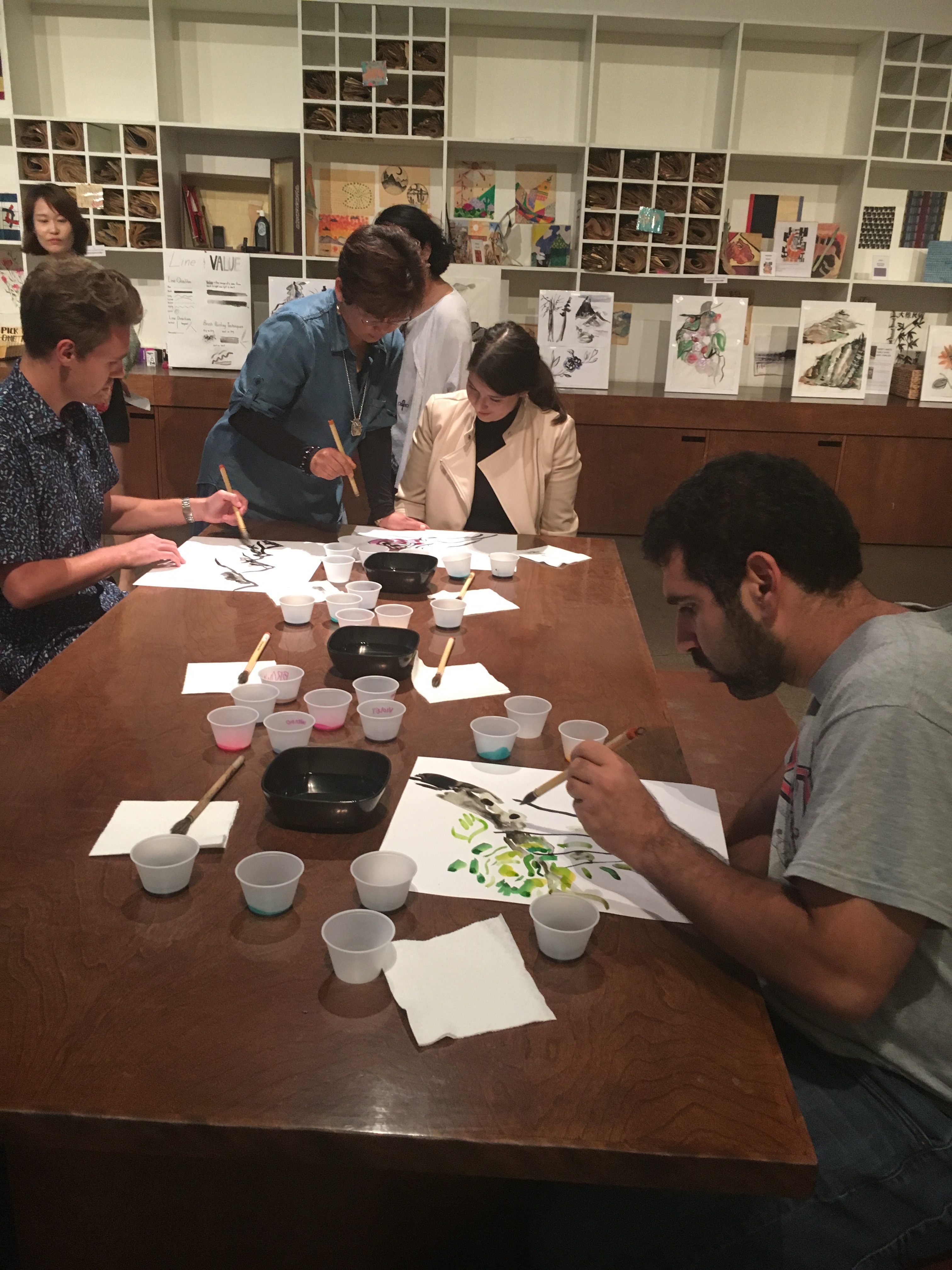 Artist Kyungsoo Lee instructs a group of participants in the techniques of Korean brush painting.