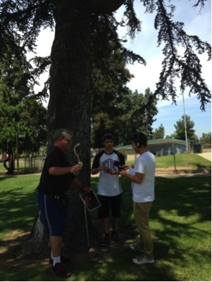Image Caption: Temperatures were over 100 degrees that day, so groups huddled under trees and tents to rehearse and record their soundscape. Educator: Fernando Cervantes