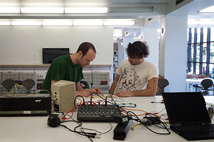 Artist Ryan Jordan and a workshop participant test an amplifier. 