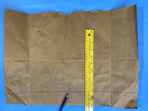 cutting out a rectangle from the brown paper grocery bag