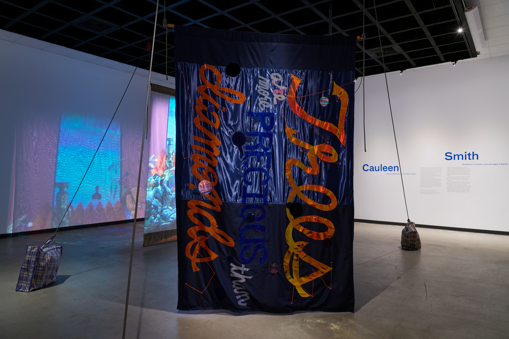 Installation view of embellished banner and video in gallery