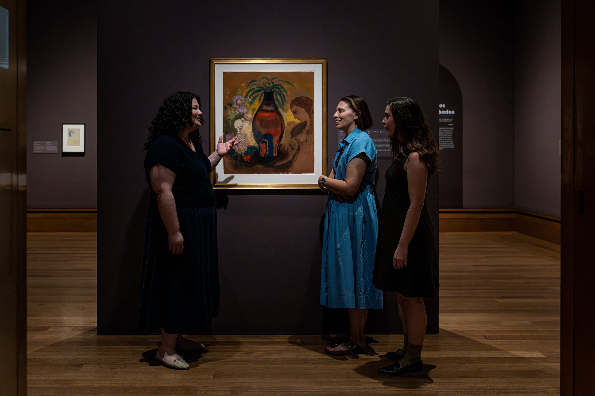 (Left to right) Danielle Canter, Michelle Sullivan, and Lucia Elledge discuss Odilon Redon’s Vase of Flowers-Large Composition, featured in the exhibition Odilon Redon: Otherworldly Visions at the Getty Center. Image: Getty Museum. © J. Paul Getty Trust
