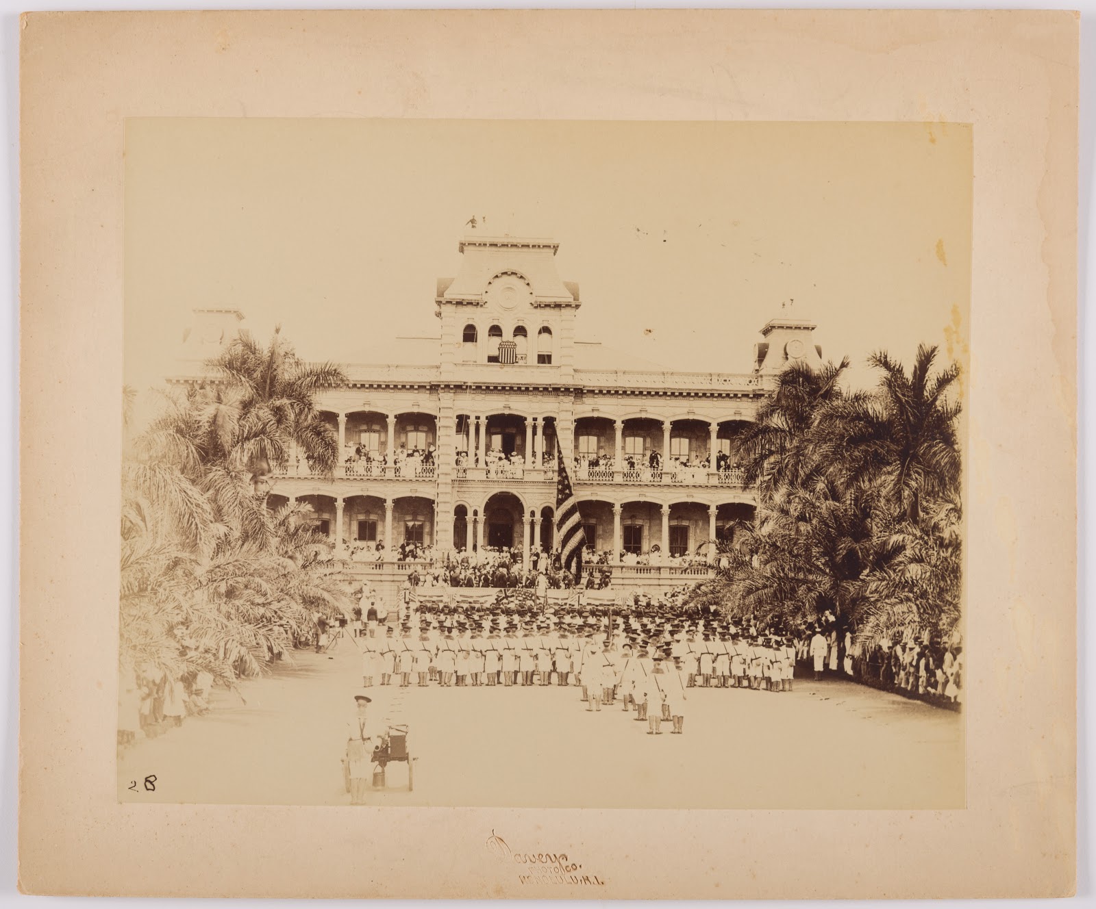 The raising of the American flag at the United States annexation ceremony at ʻIolani Palace in Honolulu, Oʻahu. The U.S.S. Philadelphia marines perform the ceremony, photographed by Frank Davey, August 12, 1898, Los Angeles County Museum of Art, partial gift of Mark and Carolyn Blackburn and purchased with funds from LACMA's 50th Anniversary Gala and FIJI Water, photo © Museum Associates/LACMA
