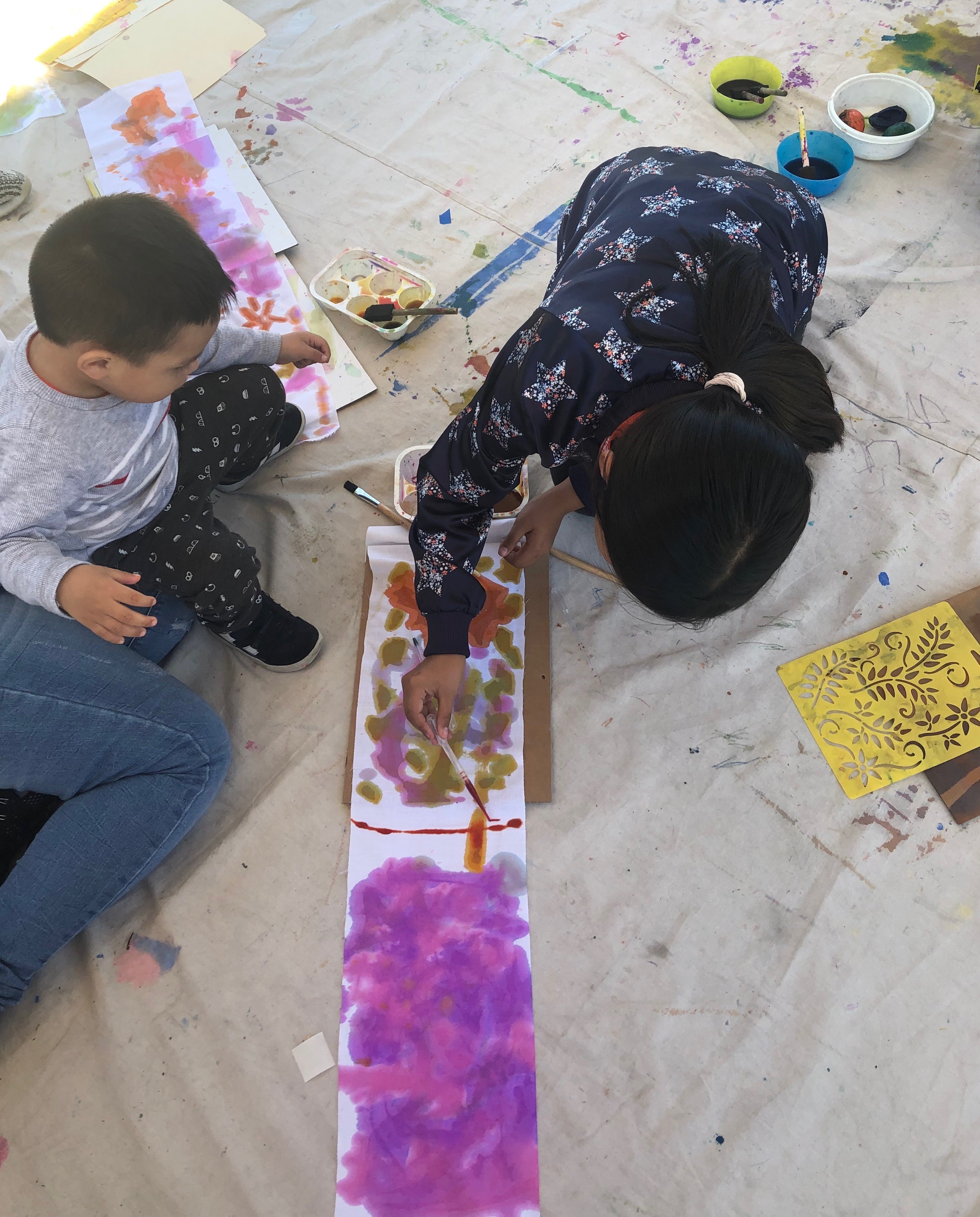 Toddlers create watercolor patterns on fabric