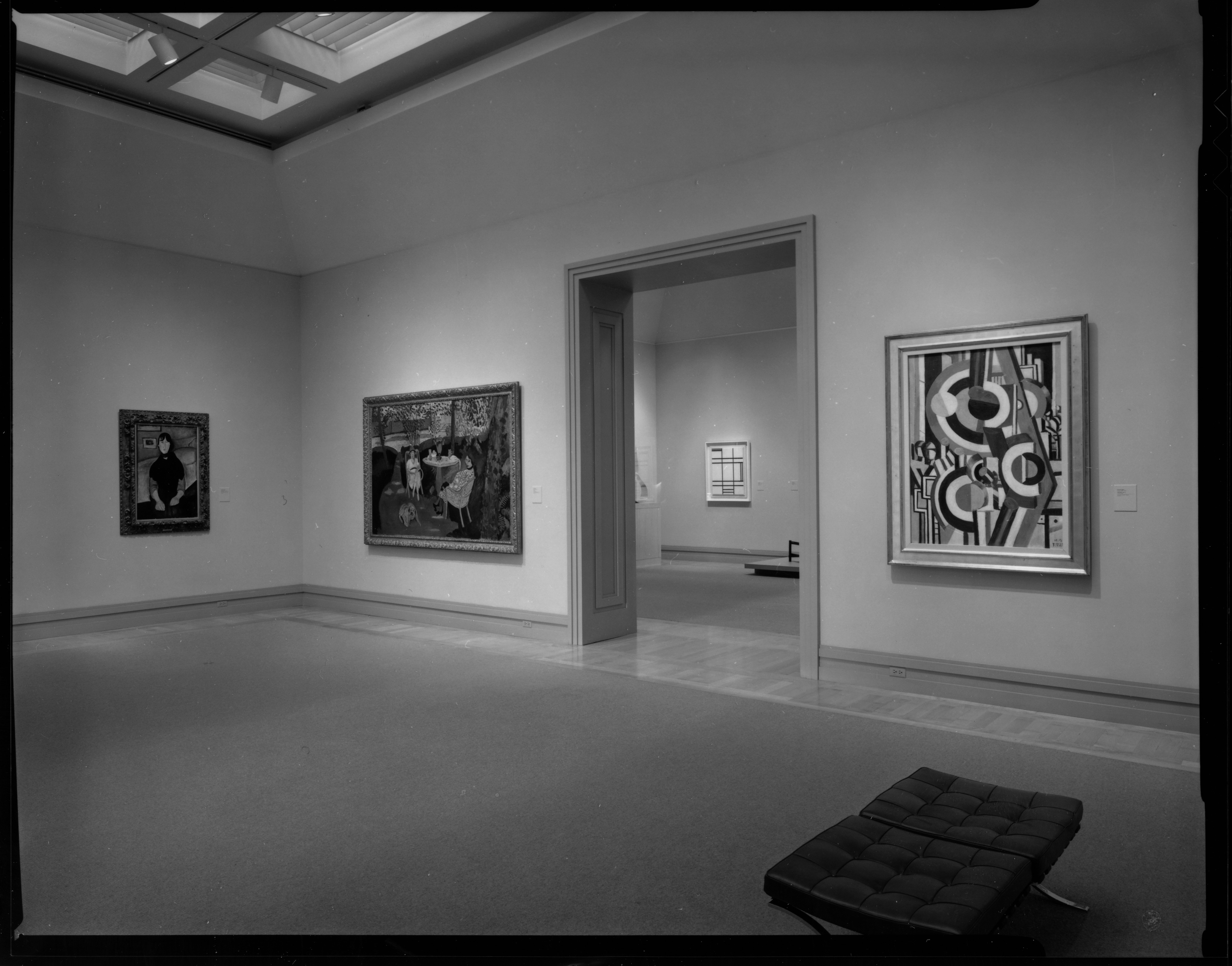 Black and white photograph with paintings on the walls