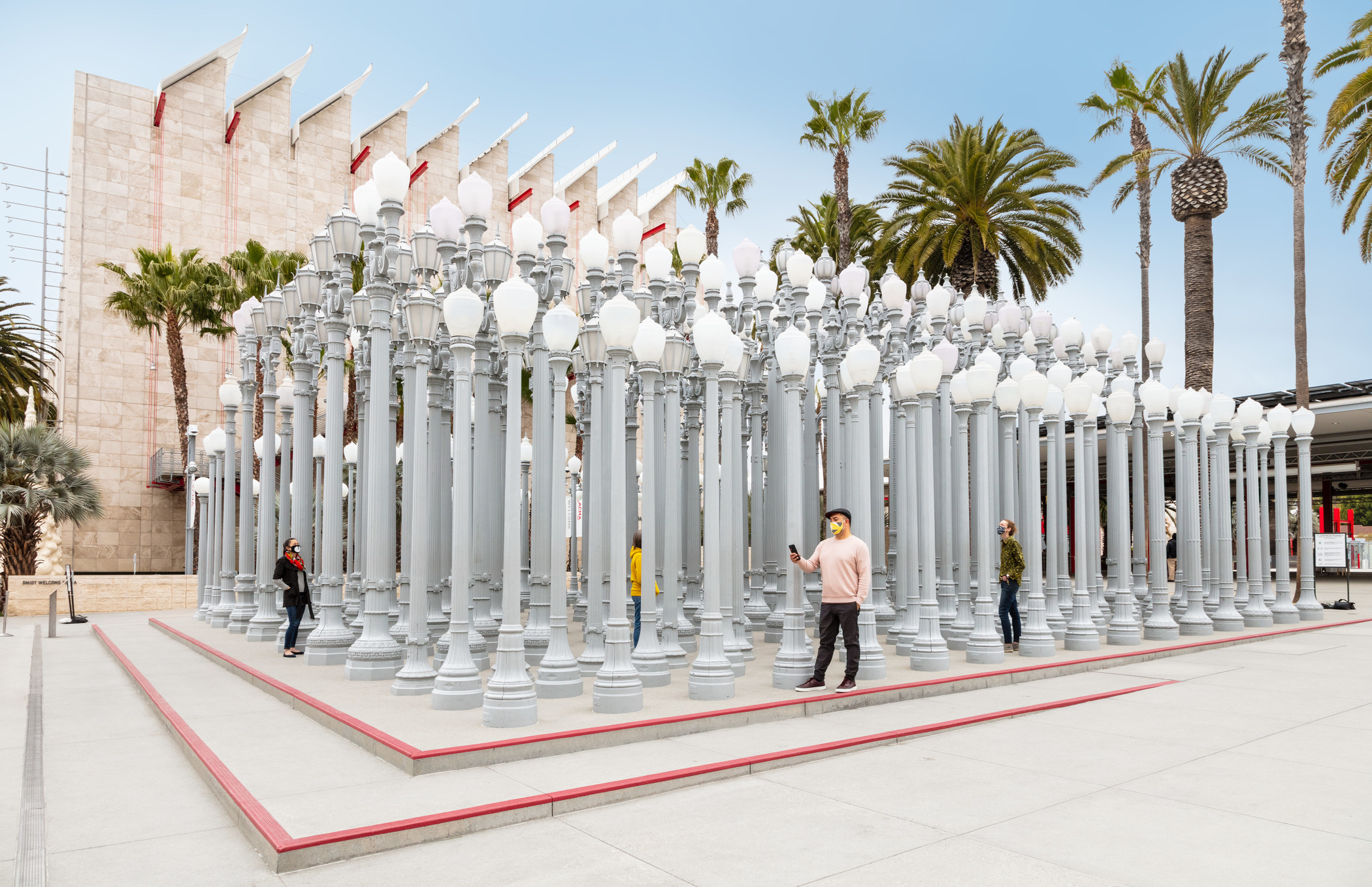 Photo of LACMA visitors at sculpture made up of streetlamps