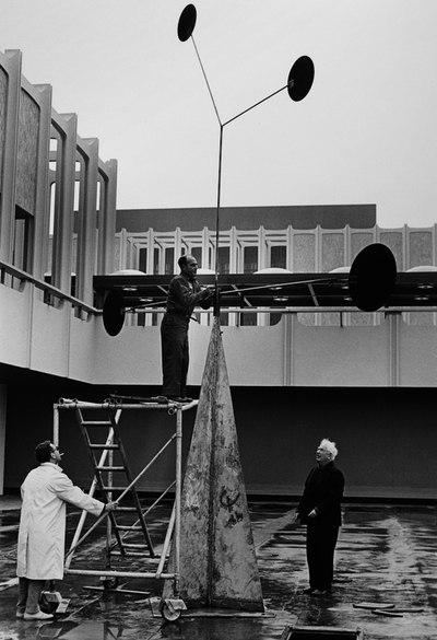 Alexander Calder and ironworker Chippy Ieronimo overseeing the installation of Three Quintains (Hello Girls), 1964, photo © 2013 Museum Associates/LACMA, photographic archives