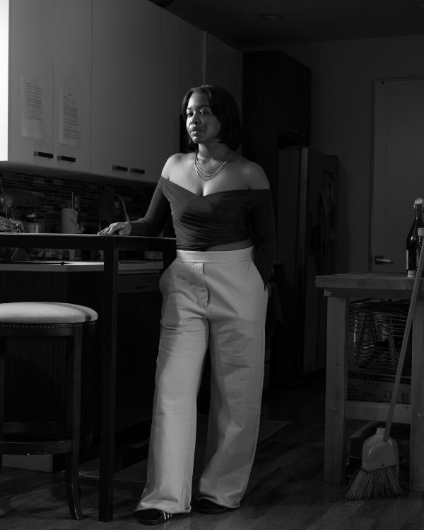 Black and white of a woman standing in a kitchen