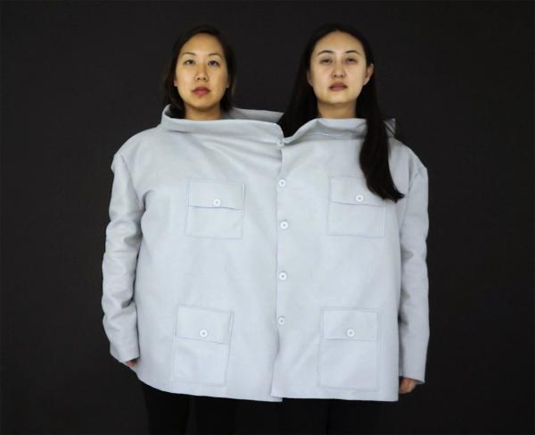 image of two women in a large shirt against a black background