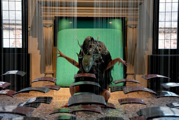 Performers in costume amid artworks by Su Xiaobai