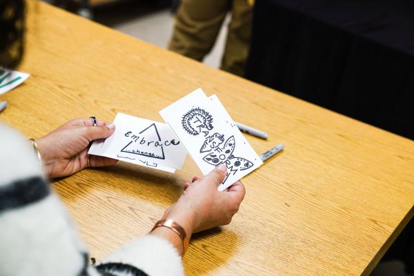 Hands holding cards with marker drawings