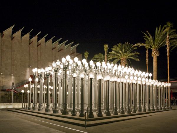 nighttime picture of Chris Burden's Urban Light illuminated at LACMA, an outdoor sculpture comprising 202 restored cast iron antique street lamps