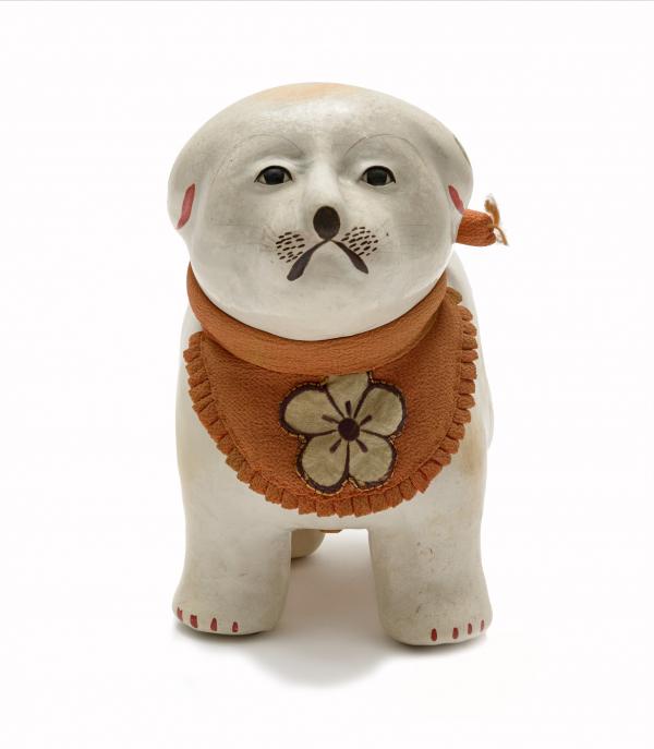 small white dog wearing an orange bib