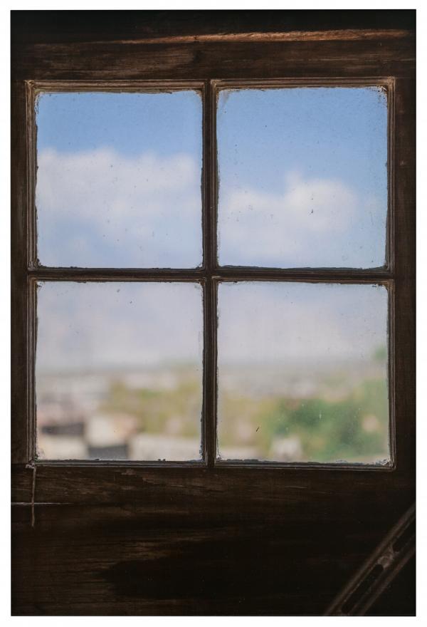 photograph of a window, looking out toward a blue sky