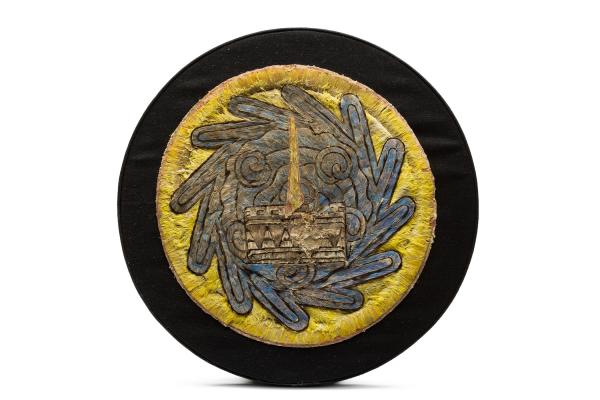 Circular black and yellow object with feather design