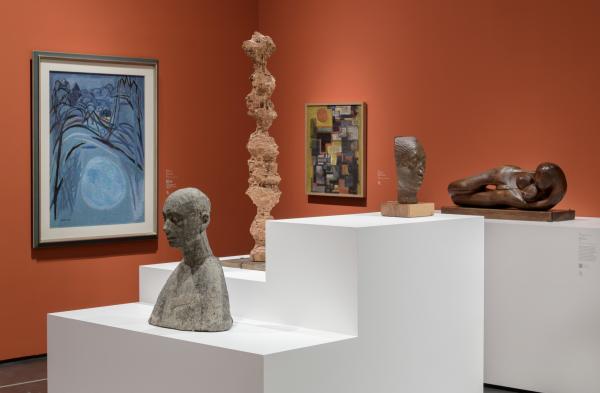 Gallery view with sculptures and paintings