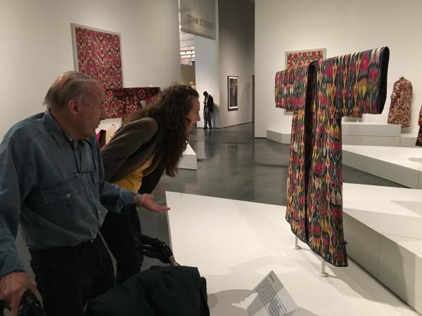 Artist Educator Elonda Norris carefully examines a textile in Power of Pattern: Central Asian Ikats from the David and Elizabeth Reisbord Collection with a Personal Connections participant.