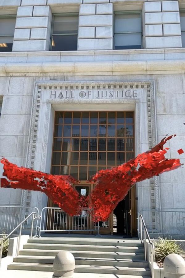 Augmented reality artwork of hands floating in front of building facade 