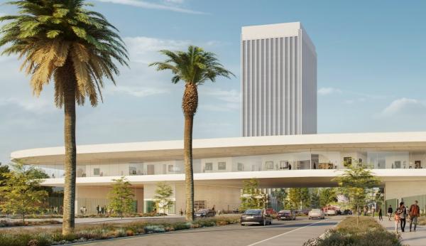 Exterior view of elevated galleries over a boulevard with palm trees and pedestrians