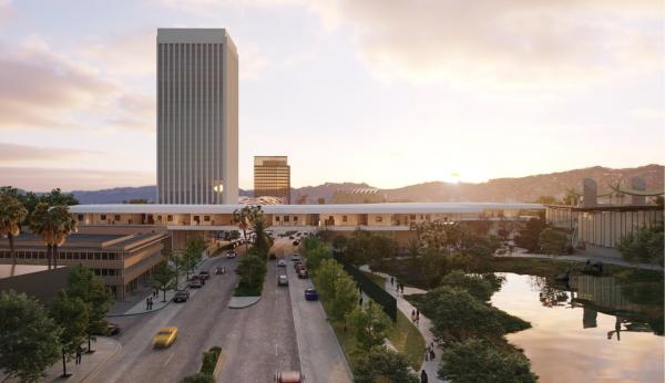 View of building bridging over a busy street, with tar pits in the foreground