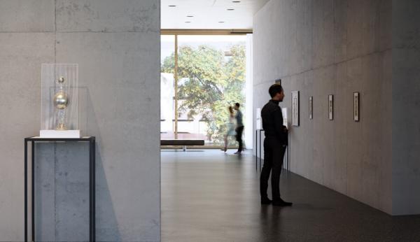 Viewers in a naturally lit gallery with art on the walls