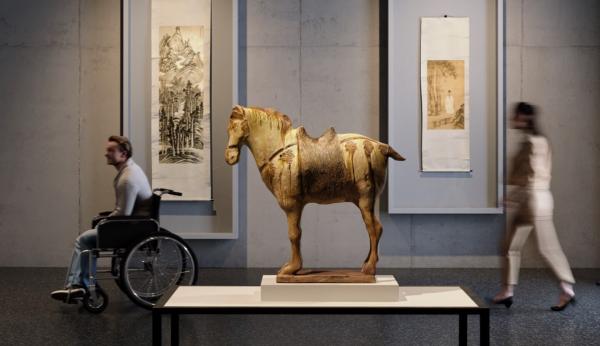 A rendering of a gallery with an ancient horse sculpture in the center and two ink painting scrolls hanging on the wall in the background. On the left is a man in a wheelchair and on the right a figure walking into the gallery.