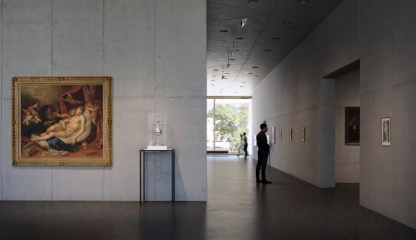 Interior view of gallery with a figure looking at art on walls