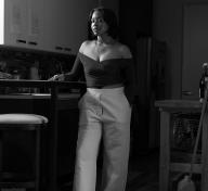 Black and white of a woman standing in a kitchen
