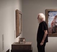 John Baldessari considering René Magritte's The Treachery of Images (This Is Not a Pipe), 1929