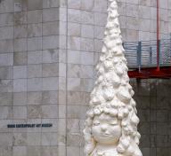 image of Yositomo Nara's outdoor sculpture Miss Forest—sculpture of a girls head, her hair shaped like a tannenbaum