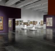 Gallery view with art on the walls that are painted purple, white, and maroon