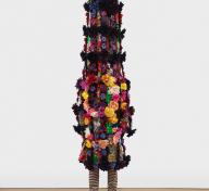Colorful sculpture with legs and oversized flower-covered body suit