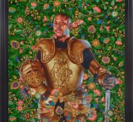 Portrait of man in golden armor emerging from foliage