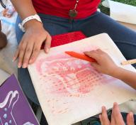 Toddler working on a pictograph rubbing in artist Eszter Delgado’s workshop