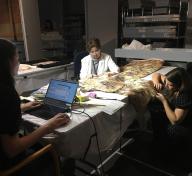 Costume and Textiles staff at work: Sharon Takeda (center) is verbally cataloging the kimono while Jennifer Iacovelli (left) enters the information into the database, and Michaela Hansen (right) is assessing the weave structure.