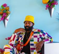 Maurice Harris sitting in a colorful floral installation