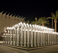 nighttime picture of Chris Burden's Urban Light illuminated at LACMA, an outdoor sculpture comprising 202 restored cast iron antique street lamps