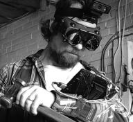 Black and white photo of man wearing hi-tech goggles