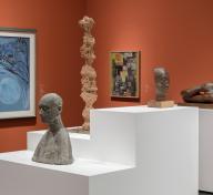 Gallery view with sculptures and paintings