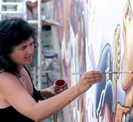 Photo of woman painting wall mural