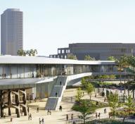 Exterior view of light gray museum building with art, landscaping, and visitors