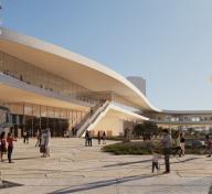 Exterior view of museum building with people and sculptures on plaza