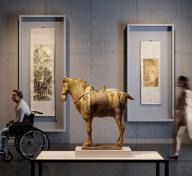 Rendering of gallery with scrolls hanging in the background and a sculpture of a horse in the foreground with visitors