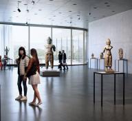 Visitors in airy gallery with floor-to-ceiling windows and artworks