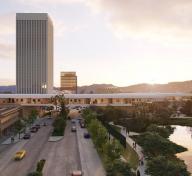 View of building bridging over a busy street, with tar pits in the foreground