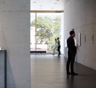 Viewers in a naturally lit gallery with art on the walls