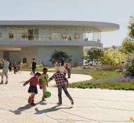 Rendering of museum building in the background with children playing in the foreground